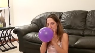 Solo Model Teen In Miniskirt Blowing Balloons In A Cozy Room
