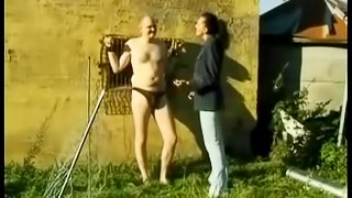 Tied up guy in glasses gets a handjob outdoors